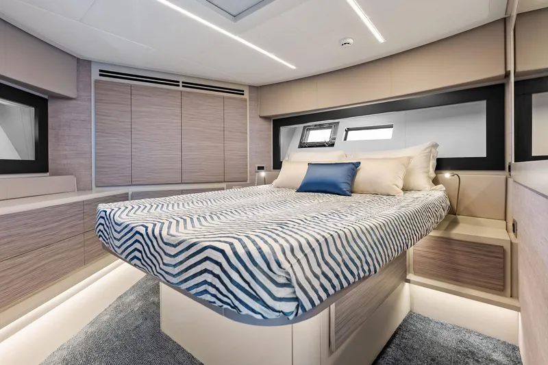 Slide: The Image of Luxurious bedroom interior of 2023 Pershing 6X yacht with modern design and striped bedding. - 50
