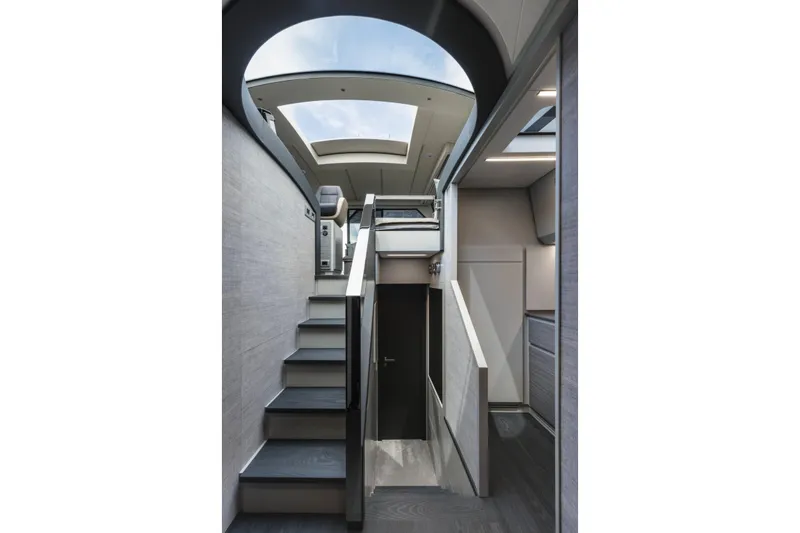 Slide: The Image of Interior of 2023 Pershing 6X yacht, featuring modern staircase and skylight. - 22