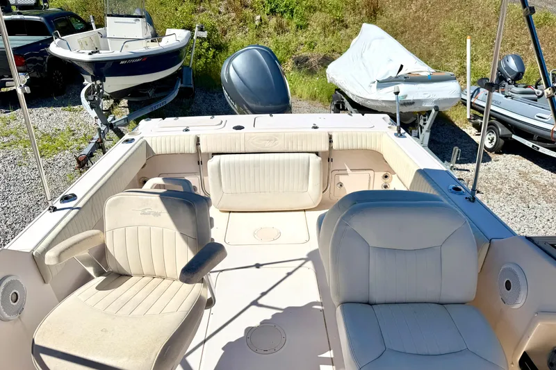 Slide: The Image of 2005 Grady-White Freedom 225 boat interior with seating, parked on gravel lot. - 2
