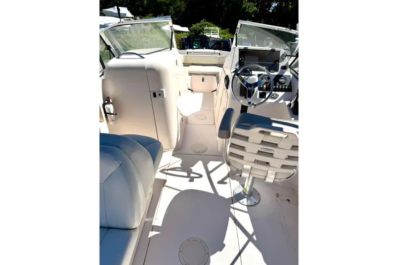 Slide: The Image of Interior view of a 2005 Grady-White Freedom 225 boat, featuring helm and seating area. - 10