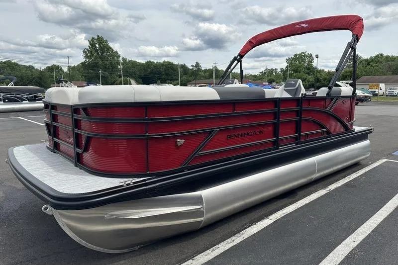 Slide: The Image of 2027 Bennington S Quad Bench 20 SSR pontoon boat with red and white design. - 1