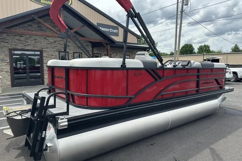Slide: The Image of 2027 Bennington S Quad Bench 20 SSR pontoon boat in vibrant red, parked outdoors. - 3