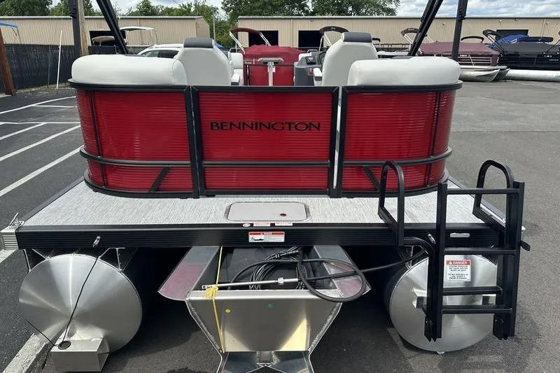 Slide: The Image of 2027 Bennington S Quad Bench 20 SSR pontoon boat, rear view, in a parking lot. - 16
