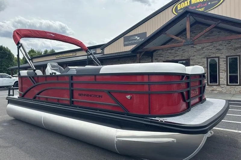 The Image of 2027 Bennington S Quad Bench 20 SSR pontoon boat with red accents, parked outside dealership. - 0