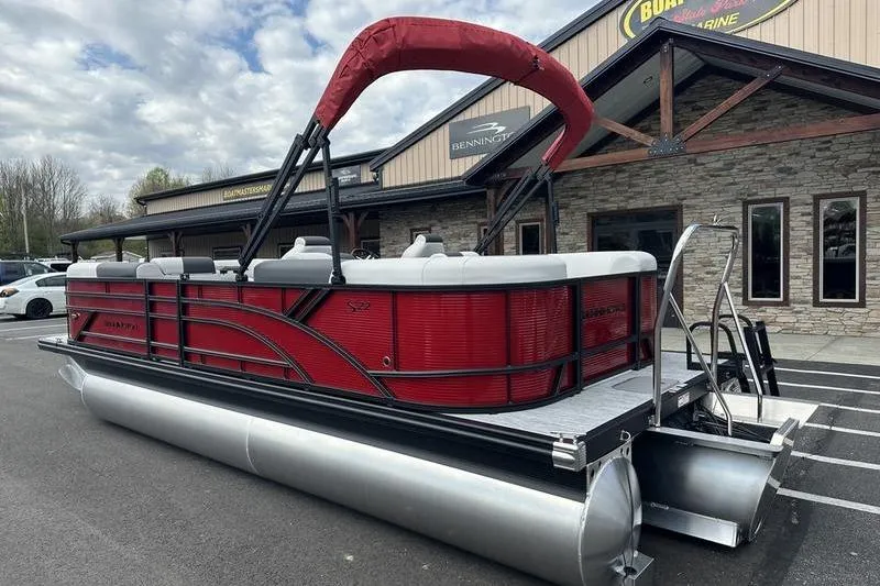 Slide: The Image of 2027 Bennington S Quad Bench 20 SSR pontoon boat, red with canopy, parked outside dealership. - 8