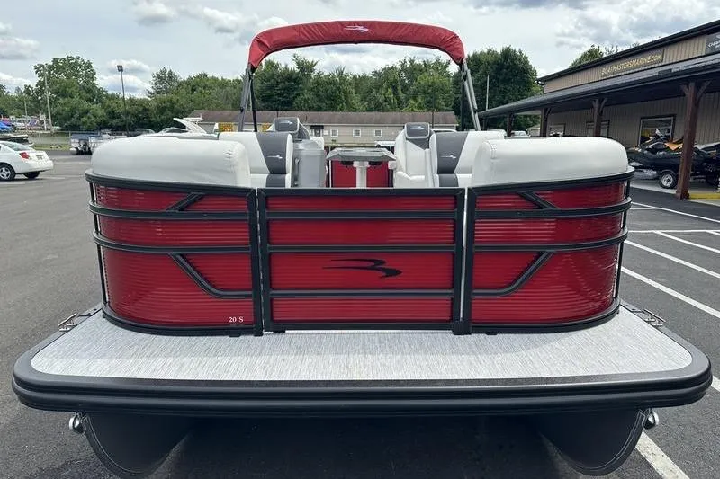 Slide: The Image of 2027 Bennington S Quad Bench 20 SSR pontoon boat, red exterior, parked outdoors. - 13