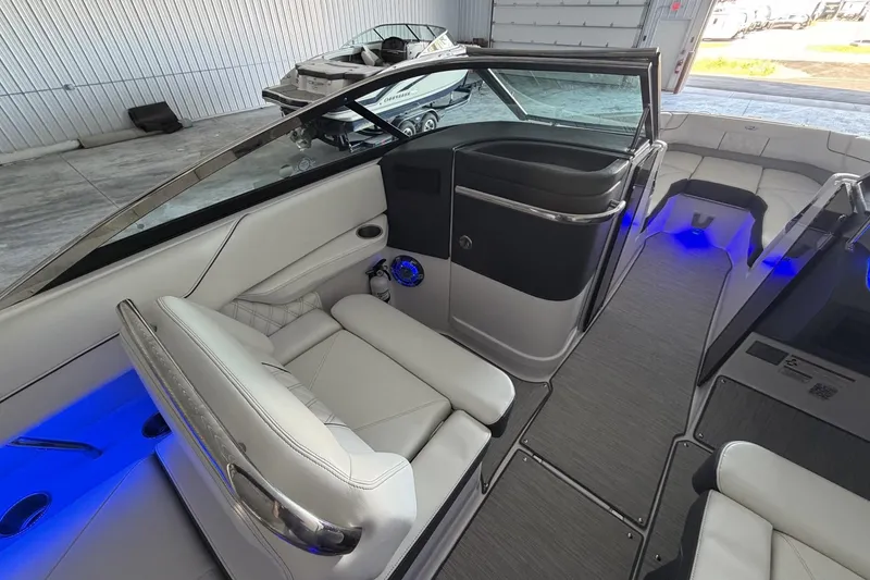 Slide: The Image of 2019 Regal LS6 boat interior with modern seating and blue LED lighting. - 13