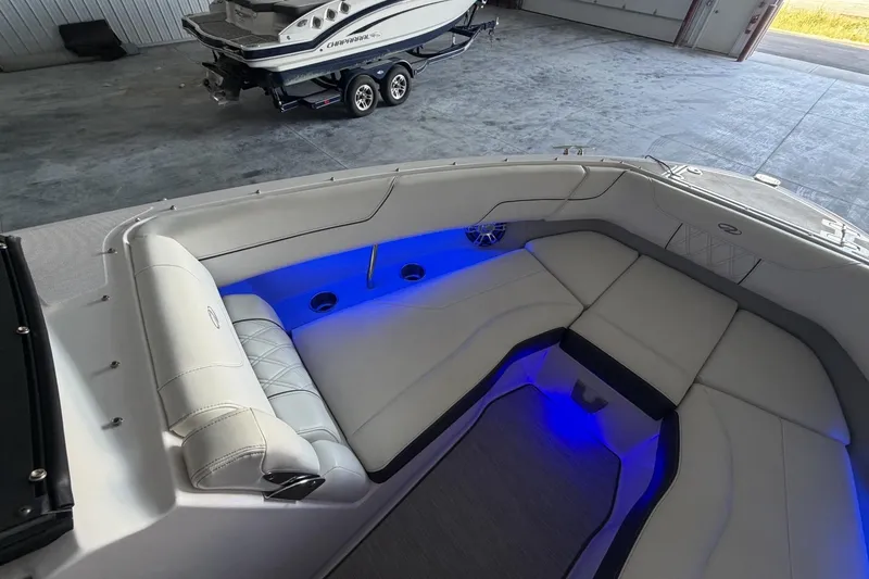 Slide: The Image of 2019 Regal LS6 boat interior with blue LED lighting and luxurious seating. - 18