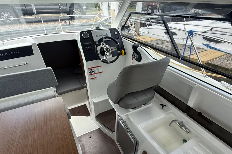 Slide: The Image of Interior of a 2019 Beneteau Antares 23 boat with steering wheel and seating. - 10