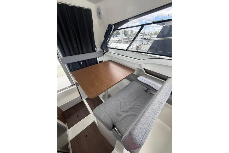Slide: The Image of Interior of 2019 Beneteau Antares 23 boat with dining area and window view. - 12