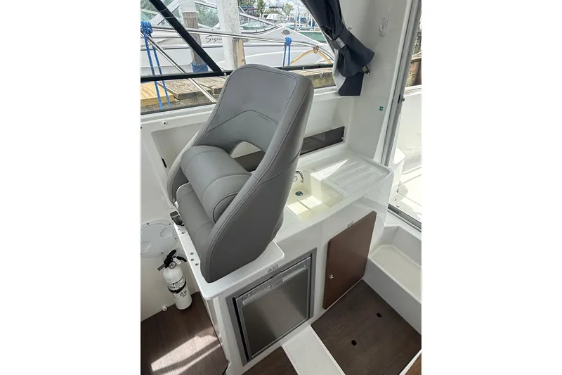 Slide: The Image of Interior of 2019 Beneteau Antares 23 boat with helm seat and kitchenette. - 14