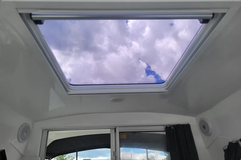 Slide: The Image of Skylight view from 2019 Beneteau Antares 23, showcasing cloudy sky through cabin window. - 19