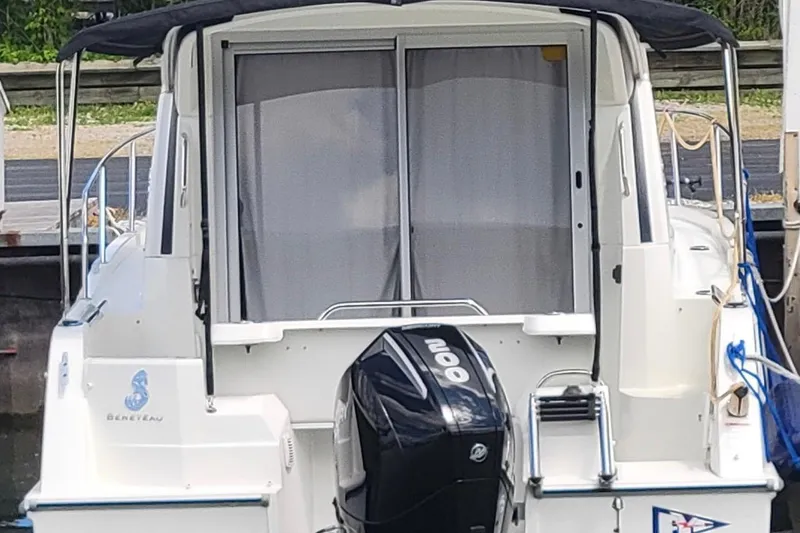 Slide: The Image of 2019 Beneteau Antares 23 boat with outboard motor, docked at marina. - 2
