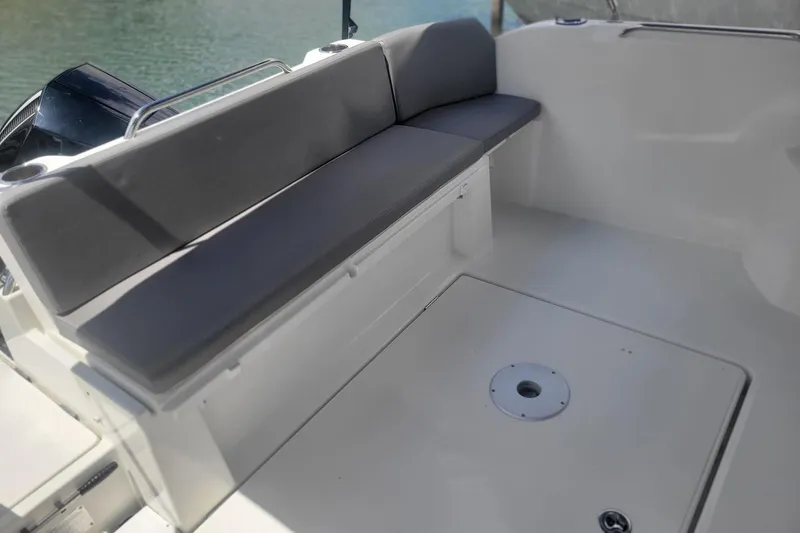 Slide: The Image of 2019 Beneteau Antares 23 boat interior with cushioned seating and sleek design. - 3