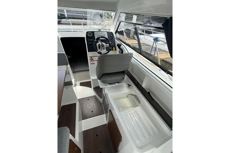 Slide: The Image of Interior view of 2019 Beneteau Antares 23 boat cockpit with steering wheel and seating. - 9