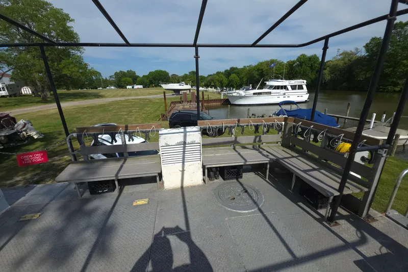 Slide: The Image of 1974 Breaux's Bay Craft passenger boat docked near a river with benches and safety equipment. - 10