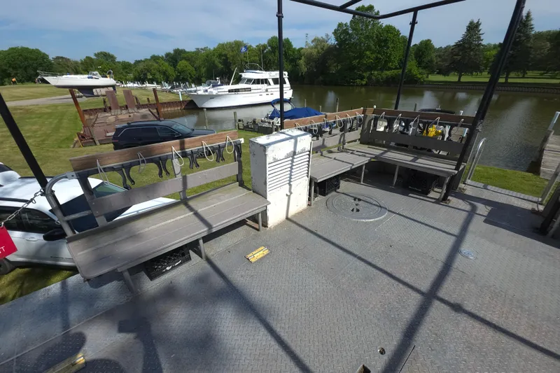 Slide: The Image of 1974 Breaux's Bay Craft passenger boat deck with benches, docked near a serene river. - 11