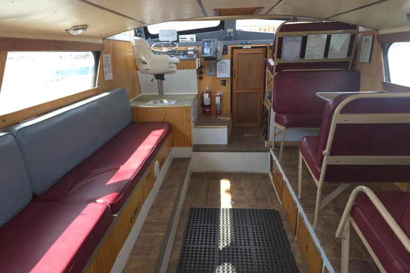 Slide: The Image of Interior of a 1974 Breaux's Bay Craft passenger boat, featuring seating and navigation area. - 16