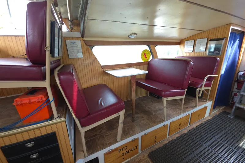 Slide: The Image of Interior of a 1974 Breaux's Bay Craft passenger boat with red seating and wood paneling. - 17