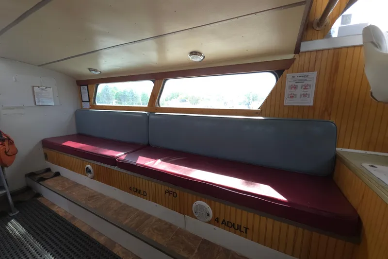 Slide: The Image of Interior of a 1974 Breaux's Bay Craft passenger boat with seating and safety instructions. - 18