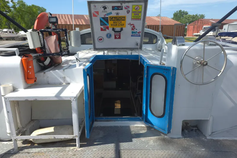 Slide: The Image of 1974 Breaux's Bay Craft Passenger boat with open hatch, safety equipment, and caution signage. - 8