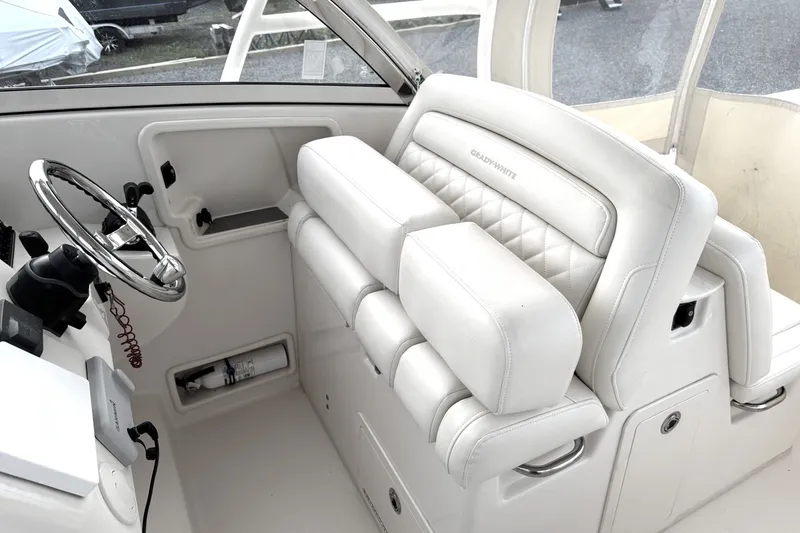 Slide: The Image of 2020 Grady-White Freedom 325 boat interior with white leather seating and steering wheel. - 8
