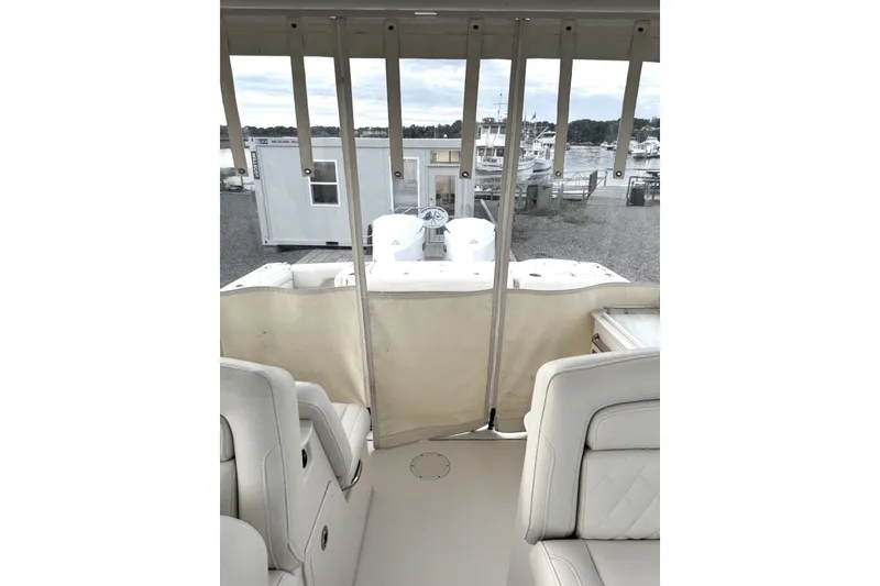 Slide: The Image of 2020 Grady-White Freedom 325 boat interior with white seating and marina view. - 13