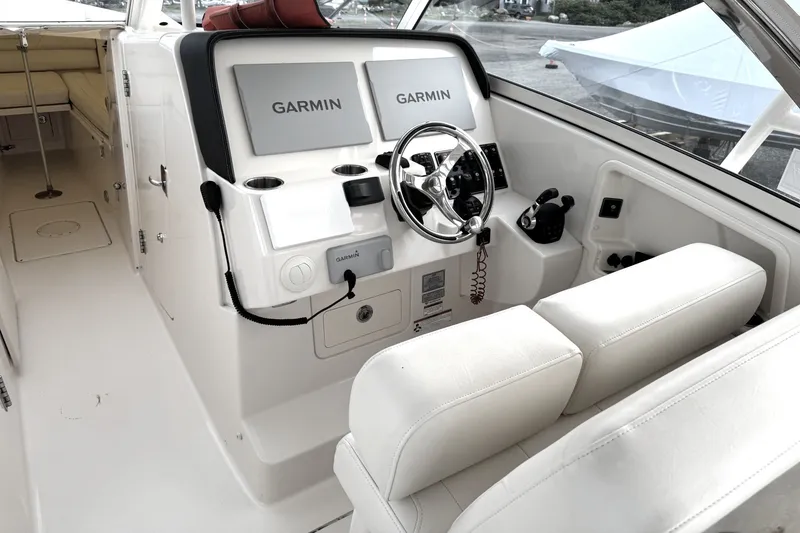 Slide: The Image of 2020 Grady-White Freedom 325 boat cockpit with Garmin navigation system and white seating. - 7