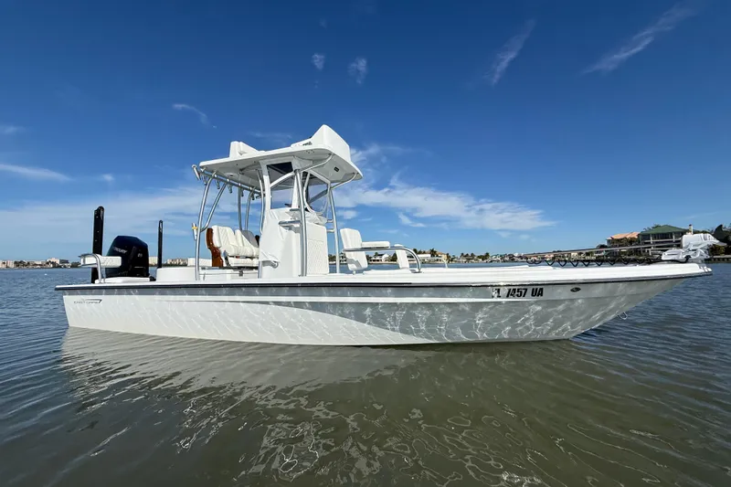 Slide: The Image of 2024 East Cape 25 Hybrid boat on calm water under clear blue sky. - 2