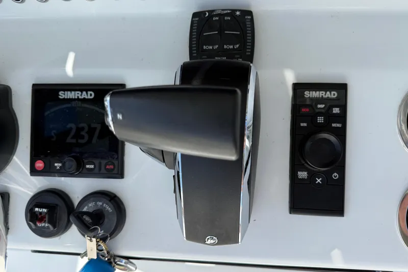 Slide: The Image of 2024 East Cape 25 Hybrid boat dashboard with Simrad controls and throttle. - 25