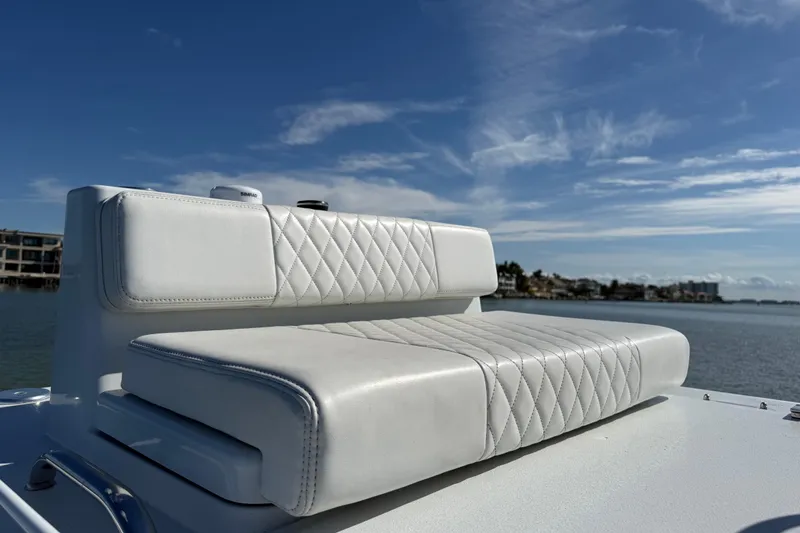 Slide: The Image of 2024 East Cape 25 Hybrid boat seat with quilted white upholstery, overlooking serene water. - 29