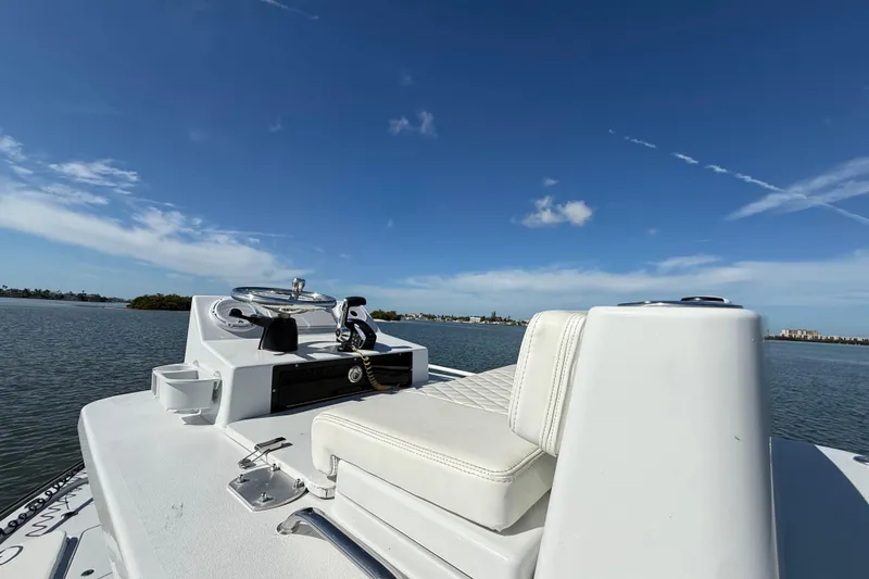 Slide: The Image of 2024 East Cape 25 Hybrid boat on calm water under clear blue sky. - 30