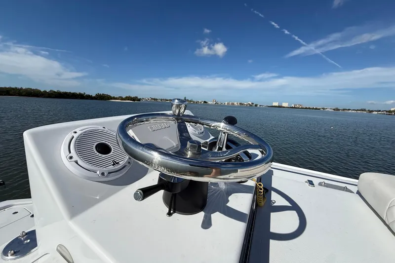 Slide: The Image of 2024 East Cape 25 Hybrid boat steering wheel with scenic water view. - 32