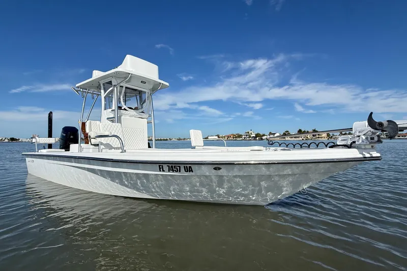 Slide: The Image of 2024 East Cape 25 Hybrid boat on calm water under clear blue sky. - 4