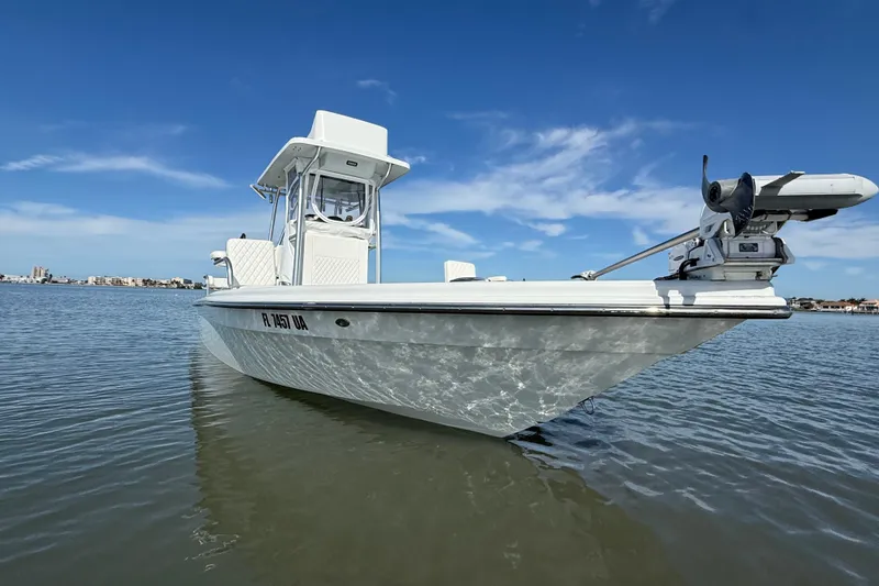 Slide: The Image of 2024 East Cape 25 Hybrid boat on calm water under clear blue sky. - 5