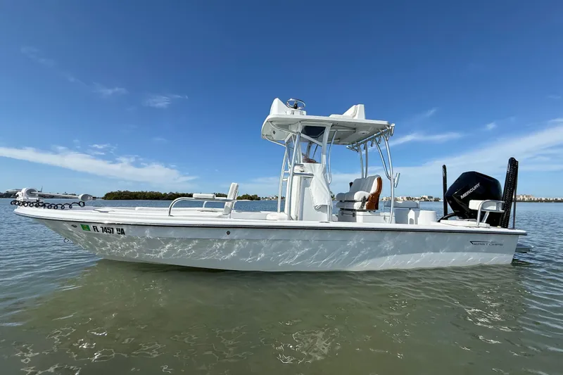 Slide: The Image of 2024 East Cape 25 Hybrid boat on calm water under clear blue sky. - 8