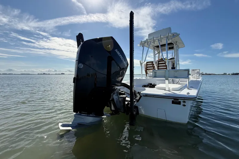 Slide: The Image of 2024 East Cape 25 Hybrid boat with Mercury engine in calm waters under blue sky. - 9