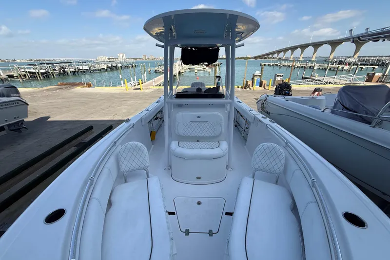 Slide: The Image of 2022 Sportsman Open 232 Center Console boat docked at marina, clear sky background. - 24