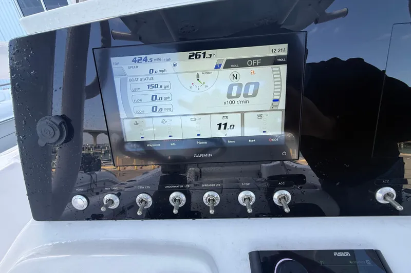 Slide: The Image of 2022 Sportsman Open 232 Center Console dashboard with Garmin display and control switches. - 65