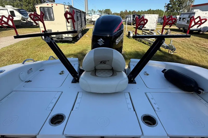 Slide: The Image of 2021 Carolina Skiff 26 Ultra Elite boat with Suzuki engine and rod holders, parked near RVs. - 34