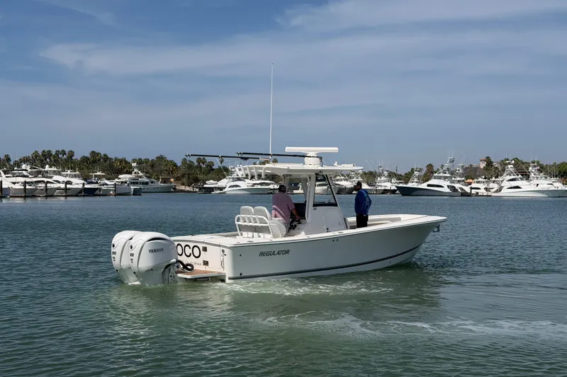 Slide: The Image of 2022 Regulator 28 boat cruising in a marina with multiple yachts in the background. - 1