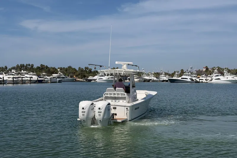 Slide: The Image of 2022 Regulator 28 boat cruising in a marina with yachts in the background. - 2