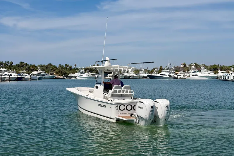 Slide: The Image of 2022 Regulator 28 boat with twin Yamaha engines in a marina setting. - 4