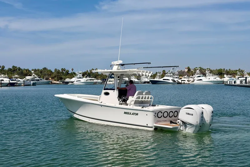 Slide: The Image of 2022 Regulator 28 boat on water, featuring twin Yamaha engines, docked at marina. - 5