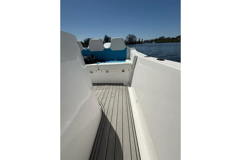 Slide: The Image of Custom Infusion 34 CC boat interior, 2021 model, featuring sleek white design and blue seating. - 19