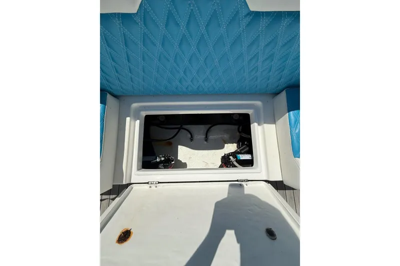 Slide: The Image of Open storage compartment on 2021 Custom Infusion 34 CC boat with blue quilted seating. - 28