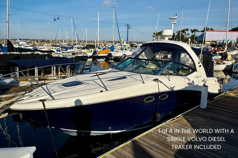 The Image of Sea Ray 290 Sundancer from 2007 docked at a marina, surrounded by other boats. - 0
