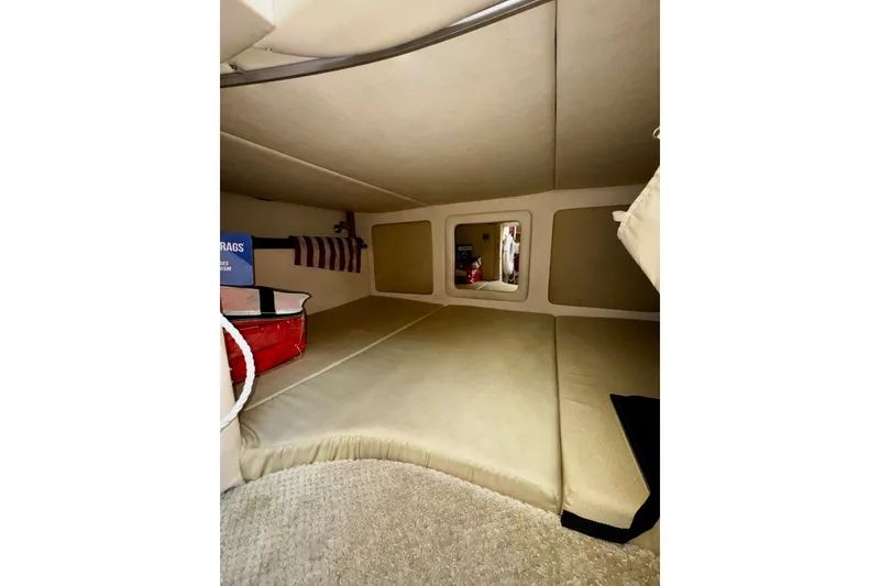 Slide: The Image of 2007 Sea Ray 290 Sundancer cabin interior with beige upholstery and storage space. - 19
