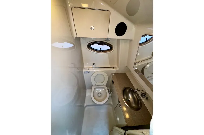 Slide: The Image of 2007 Sea Ray 290 Sundancer bathroom with toilet, sink, and porthole window. - 20