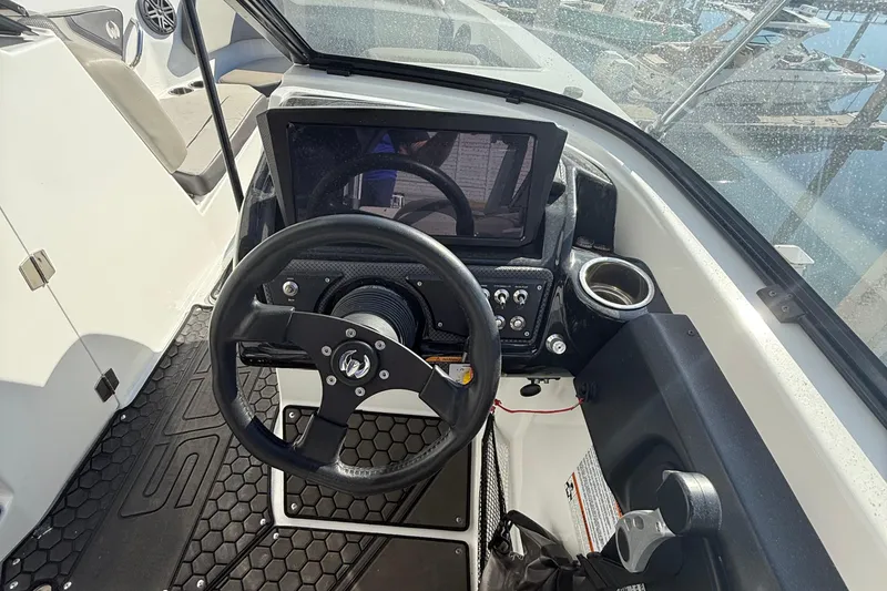 Slide: The Image of 2021 Scarab 255 ID boat dashboard with steering wheel and control panel. - 8